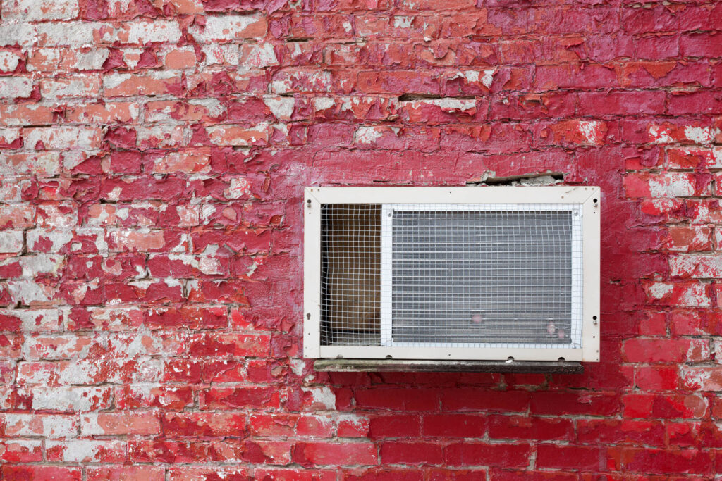 AC mounted on red wall