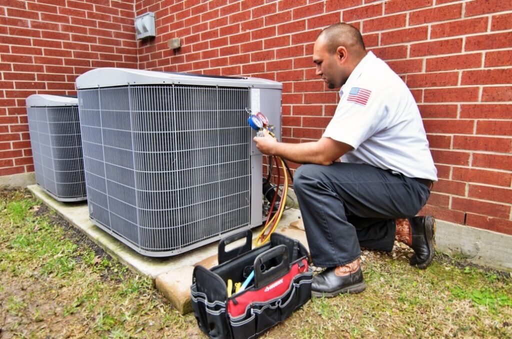 Technician performing a maintenance service on an outdoor AC unit